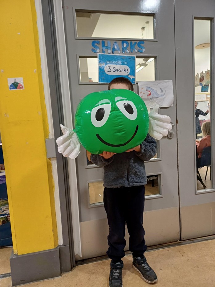 Child holding green balloon